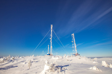 Weather meteorological station North, antennas in snow, blue clear sky