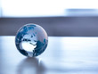 © Westend61 - Global Markets, A glass globe illustrating the world on a desk.