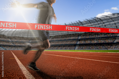 Fotografía Winning young male Athlete crosses the finish line.