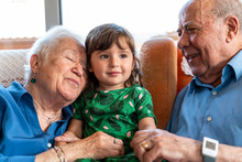 Grandparents Spending Time With The Granddaughter In Living Room