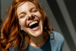 © Westend61 - Portrait of laughing redheaded woman