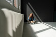 © Westend61 - Redheaded woman sitting on floor of a loft enjoying sunlight