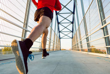 Jogger With Smartphone In Arm Pocket Running On A Bridge