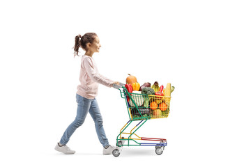 Poster - Little girl walking and pushing a shopping cart with fruits and veggies