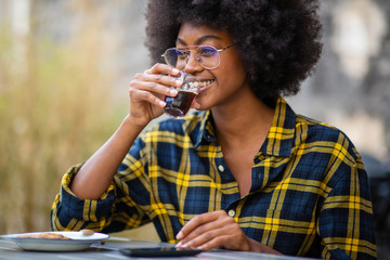 Wall Mural - young afro american woman smiling and drinking coffee