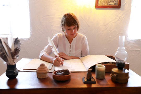 Woman writing with quill pen