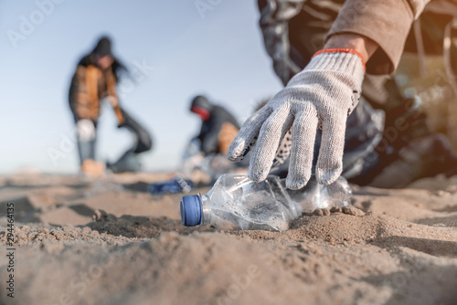 Cuadros en Lienzo Volunteer man collecting trash on the beach. Ecology concept