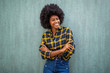 © mimagephotos - smiling young african american woman with afro hair standing arms crossed