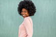 © mimagephotos - Close up side happy young black woman with afro hair against green background