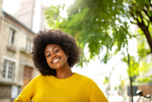 Happy Black Girl With Afro Smiling Outside In City