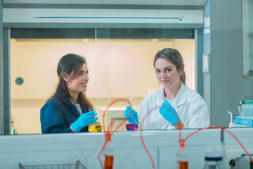 Wall Mural - two young female scientist doing experiments in laboratory.