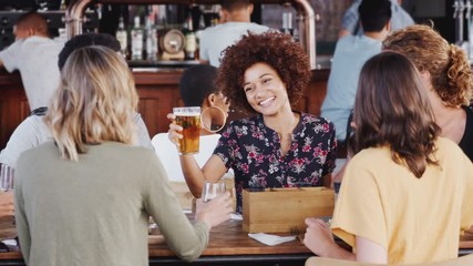 Wall Mural - Group Of Young Friends Meeting For Drinks And Food Making A Toast In Restaurant