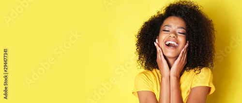 Fotografía Super happy afro-american girl isolated on yellow background.