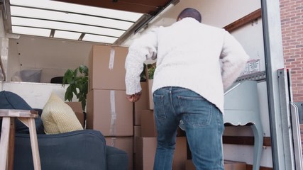 Wall Mural - Man Unloading Boxes From Removal Truck Outside New Home On Moving Day