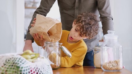 Wall Mural - Father Helping Son To Refill Food Containers At Home Using Zero Waste Packaging