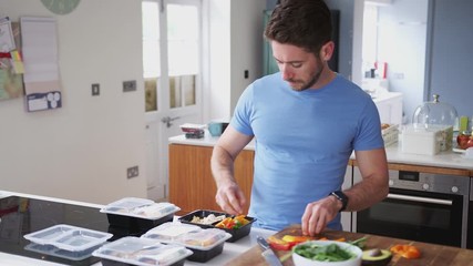 Wall Mural - Man Wearing Fitness Clothing Preparing Batch Of Healthy Meals At Home In Kitchen