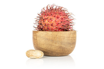 Group of one whole one piece of unpeeled fresh red rambutan in wooden bowl isolated on white background