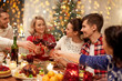 © Syda Productions - holidays and celebration concept - happy friends having christmas dinner at home, drinking red wine and clinking glasses