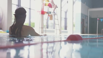 Wall Mural - Underwater Shot Of Woman Swimming In Indoor Pool 