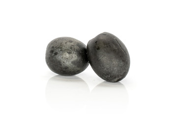 Group of two whole tasty black olive isolated on white background