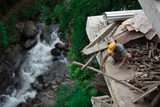 Fototapeta  - Robotnik budujący dom nad górskim strumieniem w Banaue na Filipinach 