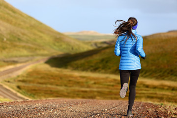 running woman on trail run doing fitness exercise in spring autumn mountains. person training outsid