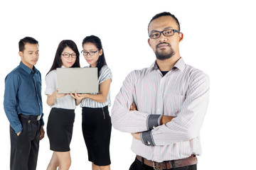 Wall Mural - Confident male business leader with team on studio