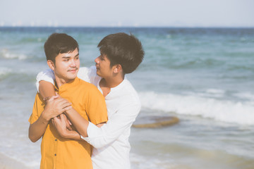 Homosexual portrait young asian couple standing hug together on beach in summer, asia gay going tourism for leisure and relax with romantic and happiness in vacation at sea, LGBT concept.