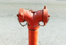 Close Up Red Standpipe Hydrant System For Fire Prevention And Fighting Standing On Footpath With Blurred Street Background.