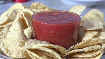 Canvas Print - Dipping a corn chip into homemade salsa slow motion