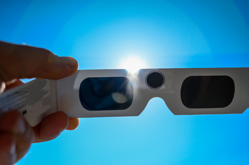 Sun viewed behind darkened solar eclipse glasses