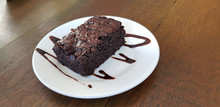 Chocolate Brownie In White Plate On Wood Table Background