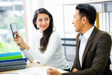 Business woman presenting the marketing report by digital tablet to manager at meeting