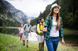 © NDABCREATIVITY - Group of friends hikers walking on a mountain at sunset