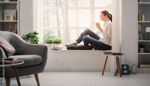 Cuadros en Lienzo Woman relaxing at home and having coffee