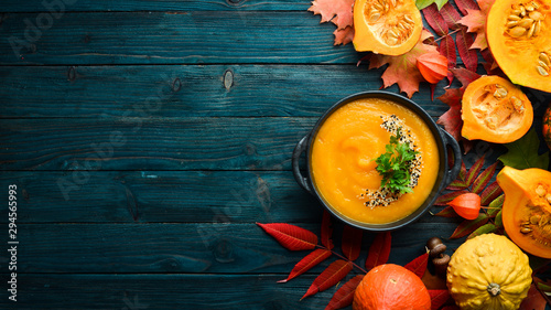 Fotografía Pumpkin soup with pumpkin and colored autumn leaves