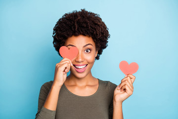 Poster - Close up photo of amazed excited emotions expression afro american girl hold little paper card close cover her face have fun on date for 14-february wear green sweater isolated over blue color