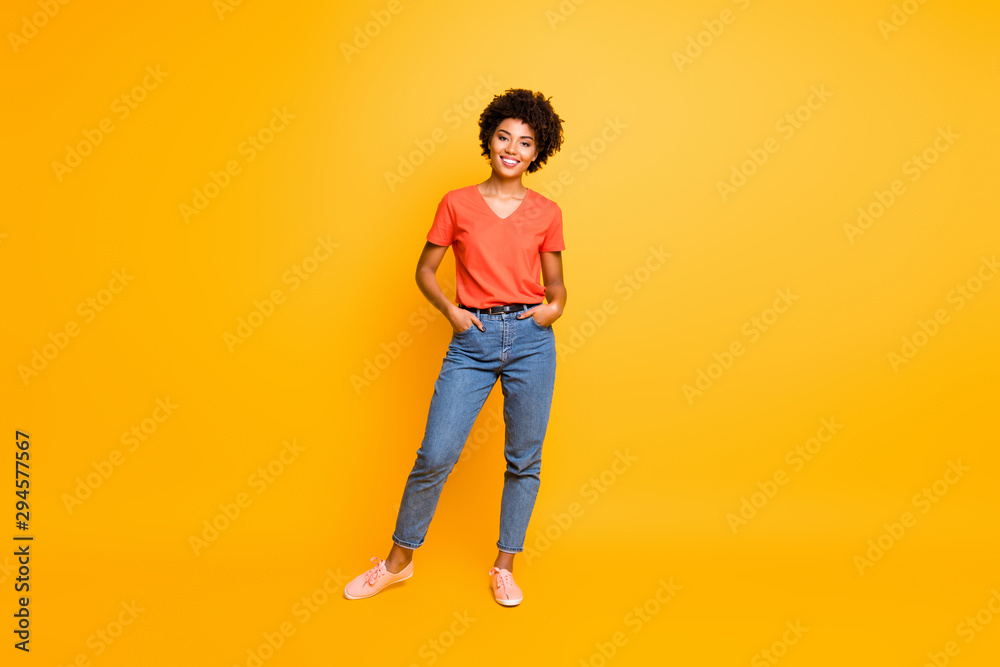 Full length body size photo of cool swag good black millennial girl posing in front of camera showing her coolness wearing jeans denim sneakers isolated over vibrant color background - obrazy, fototapety, plakaty 