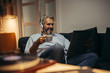 © cherryandbees - mid aged man relaxing home and listening music on record playermid aged man relaxing home and listening music on record player