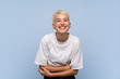 © luismolinero - Teenager girl with white short hair over blue wall smiling a lot