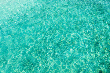 top view of ripple surface of crystal clear sea with sun reflection. concept for texture background 