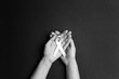 © WindyNight - Female hands holding white ribbon on black background. November lung cancer awareness month.