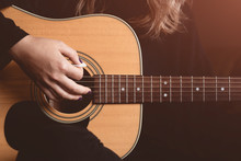 Girl Plays An Acoustic Guitar. Close-up Of Strings