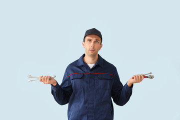 Wall Mural - Confused car mechanic on color background