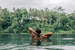 © Alena Ozerova - Woman enjoying tropical rain while swimming in infinity pool on Bali