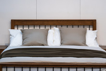 Modern White And Brown Fabric Pillows On The Classic Wooden Bed Interior Decoration