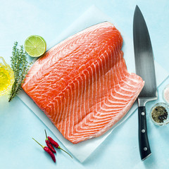 Fresh salmon slice on a wooden cutting board with a chef's knife on the table. cooking recipe. food background. fresh fish products