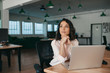 © mavoimages - Young businesswoman thinking about work while sitting at her desk