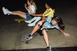© Drobot Dean - Image of amazed multinational girls riding on skateboards at night