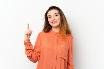 Wall Mural - Young brunette girl over isolated white background showing and lifting a finger in sign of the best